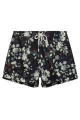 A pair of men's floral print swim trunks featuring a dark navy base with white and gray floral motifs and a white drawstring, laid flat against a light gray background.